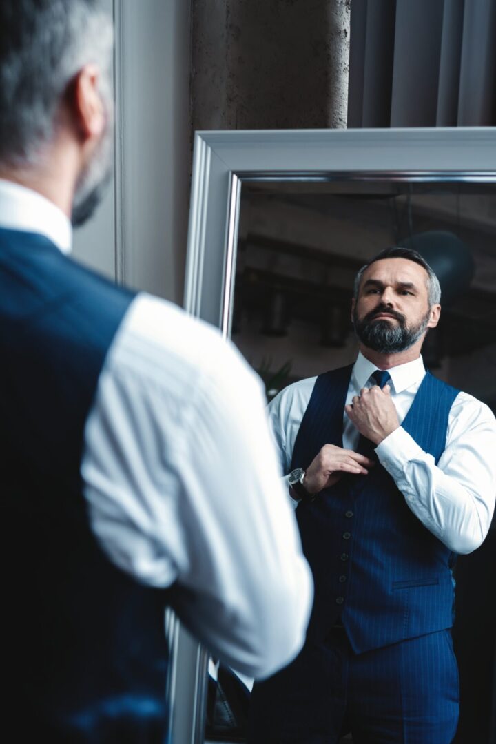 Man looking in mirror with confident expression, symbolizing self-worth and empowered dating mindset Man evaluating his reflection, symbolizing personal growth and intentional dating choices