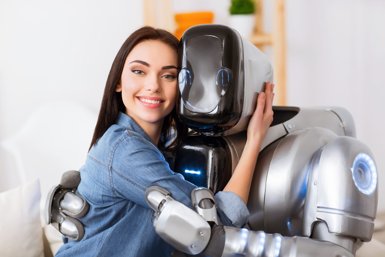 “Dating in the Digital Future: What’s Real in a Virtual World?” A young woman with a warm smile is embracing a humanoid robot. The setting is softly lit and futuristic, blending human emotion with advanced technology. The contrast highlights both the intimacy and irony of forming connections in a tech-driven world.